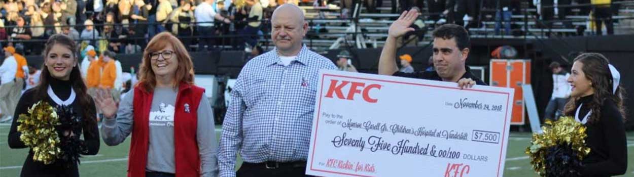 Group of five receiving the KFC Kickin' for Kids check