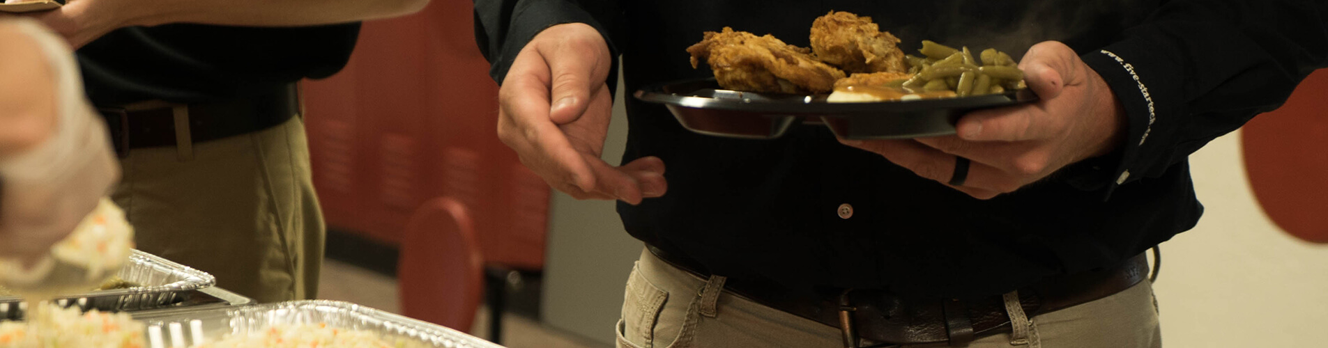 Person picking up a a plate of fried chicken